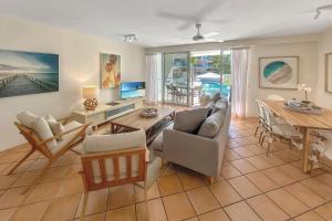 uma sala de estar com um sofá e uma mesa em The Cove Noosa - Apartment 6 em Noosa Heads