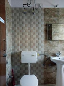 a bathroom with a toilet and a sink at Vamoose - Yog Homestay in Chaubattia