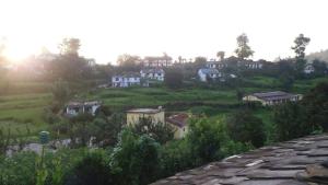 a group of houses on top of a hill at Vamoose - Yog Homestay in Chaubattia