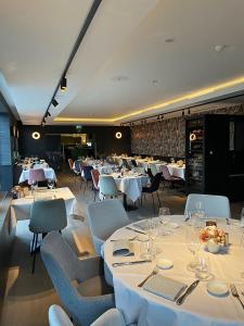 a dining room with white tables and chairs at Biznis Hotel in Lokeren