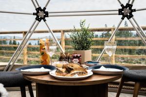 una mesa con pan y copas de vino y dos telescopios en Arctic Dome Gudbrandsdalen en Sør-Fron