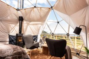 Zimmer mit einem Zelt mit Stühlen und einem Tisch in der Unterkunft Arctic Dome Gudbrandsdalen in Sør-Fron