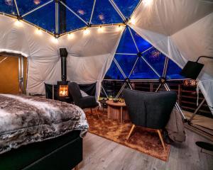 a bedroom in a dome tent with a bed and chairs at Arctic Dome Gudbrandsdalen in Sør-Fron