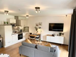 a living room with a couch and a kitchen at Ferienwohnung Stamer in Eckernförde