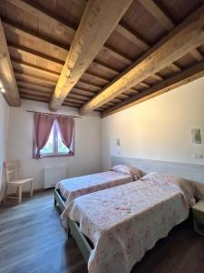 聖塞韋里諾馬爾凱的住宿－Agriturismo Collamato，一间卧室设有两张床和窗户。