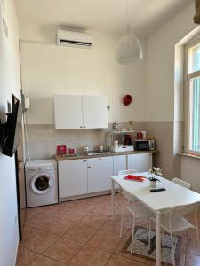 eine Küche mit einem Tisch und einer Waschmaschine in der Unterkunft Appartamento Cataleya Home in Brindisi