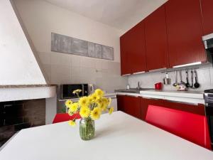 una cocina con un jarrón de flores amarillas en un mostrador en Casa Viola, San Vito a 25 minuti da Costa Rey e Villasimius, en San Vito