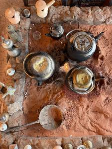 um grupo de panelas e frigideiras sobre uma mesa em Enad desert camp em Wadi Rum