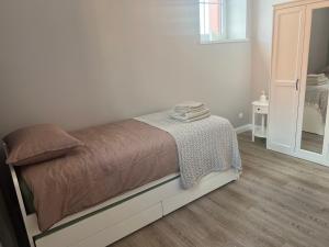 een slaapkamer met een bed met een tafel en een spiegel bij Apartamentai Jums in Telšiai