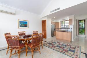a dining room with a table and chairs and a kitchen at The Point Villa 2 in Port Douglas