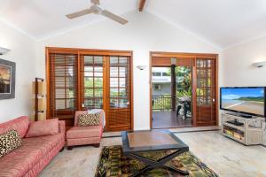 uma sala de estar com um sofá e uma televisão em The Point Villa 2 em Port Douglas