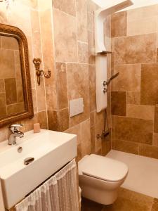 een badkamer met een wastafel, een toilet en een spiegel bij Chez Nelly : Escapade campagne Toulousaine in Bessières