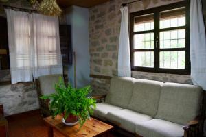 ein Wohnzimmer mit einem Sofa und 2 Fenstern in der Unterkunft Casa Rural la Laguna 