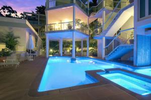 a swimming pool in front of a building at The Hill Villa 2 in Port Douglas