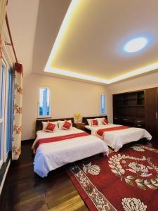 1 dormitorio con 2 camas y alfombra roja en Ngọc Phương Anh Homestay Huế en Hue