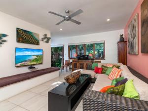 een woonkamer met een bank en een tv bij Oasis Beachfront Mirage in Port Douglas