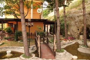 eine Holzbrücke über einen Teich im Garten in der Unterkunft B&B il Castello in Vico del Gargano