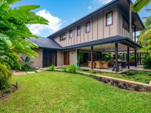 een huis met een grote tuin ervoor bij Oasis Beachfront Mirage in Port Douglas