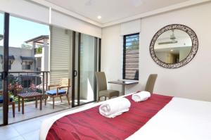 - une chambre avec un lit et un balcon dans l'établissement 207 Temple By The Sea, à Port Douglas