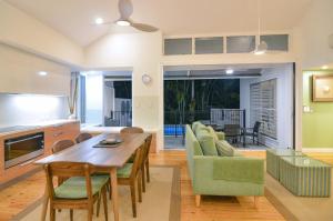 uma cozinha e sala de estar com mesa e cadeiras em Beach Villa 5 em Port Douglas