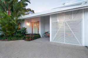 una casa con una puerta de garaje blanca y algunas plantas en Beach Villa 5, en Port Douglas