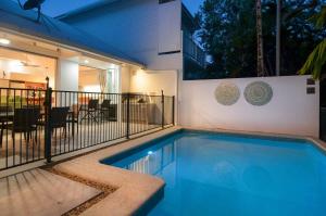 a swimming pool in front of a house at Beach Villa 5 in Port Douglas