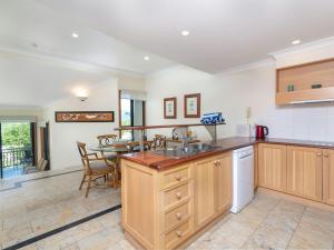 a kitchen with wooden cabinets and a table and chairs at The Point Villa 10 in Port Douglas