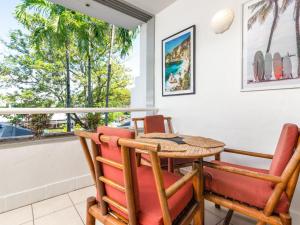 ein Esszimmer mit einem Tisch, Stühlen und einem Fenster in der Unterkunft Portside Studio in Port Douglas