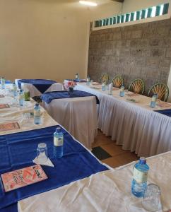 eine Reihe von Tischen in einem Raum mit blauen und weißen Tischen in der Unterkunft EQUINE RESORT in Gitura