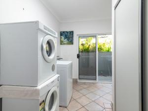 a white laundry room with a washer and dryer at Blue Sage in Port Douglas