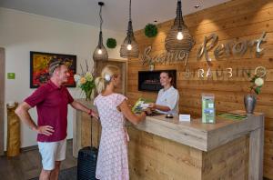 Ein Mann und eine Frau stehen vor einer Kasse in der Unterkunft Bachhof Resort Hotel in Kirchroth