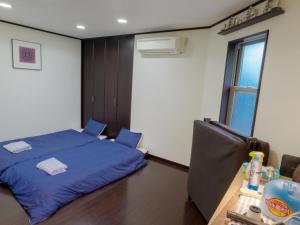 a bedroom with a blue bed and a window at Ikinomannaka - Vacation STAY 58080v in Iki