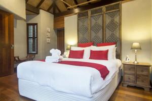 Un dormitorio con una gran cama blanca con almohadas rojas. en 2B Far Pavilions, en Port Douglas 11 fotos más
