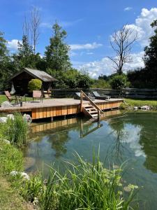 a wooden bridge over a pond with a gazebo at FEWO Studio7 in Vorderelsenwang