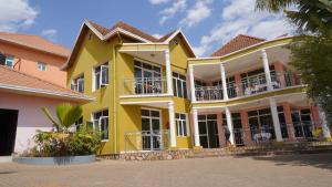 a yellow house with balconies on a street at DANA KIGALI HOTEL in Kigali +36 photos