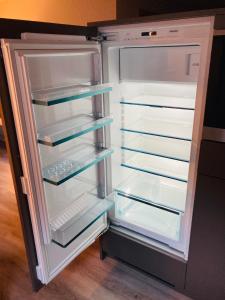 an empty refrigerator with its door open in a kitchen at Ferienwohnung Morgengruss in Sankt Niklaus