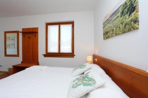 1 dormitorio con 1 cama con sábanas blancas y ventana en Agriturismo Spolert Winery, en Prepotto