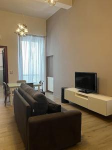 a living room with a couch and a flat screen tv at La casa di Alice in Parma