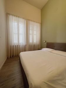 a bedroom with a large white bed and a window at La casa di Alice in Parma