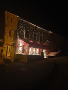 a building lit up at night with lights on it at Auberge des Arènes in Mugron