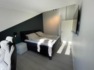 1 dormitorio pequeño con 1 cama y 1 silla en Erling Skjalgssons gate 32a, en Oslo