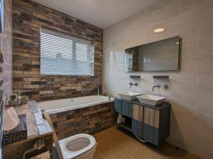 a bathroom with two sinks and a tub and a toilet at Urban Zen Den in Town Moor