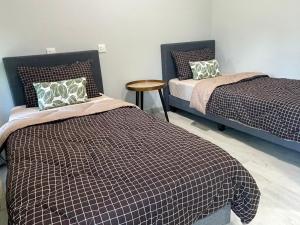 a bedroom with two beds and a wooden table at Jesselton Quay homestay with Free 1 parking by StayPlace in Kota Kinabalu