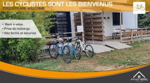 deux vélos garés devant un bâtiment dans l'établissement Appart'hôtel Les Prés Blondeau de 1 à 10 personnes, à Les Rosiers