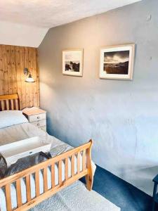a bedroom with a bed and two pictures on the wall at Gorffwysfa Cottage, Garnfadryn, nr Abersoch in Dinas