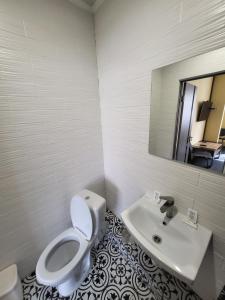 a bathroom with a white toilet and a sink at Амстердам in Khmelnytskyi +20 photos