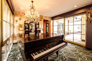 ein Klavier im Wohnzimmer mit einem Kronleuchter in der Unterkunft STEIGER Hotel Elbschlösschen Rathen in Kurort Rathen