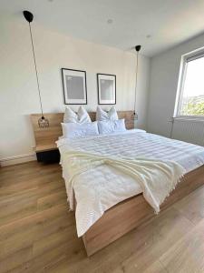 - une chambre avec un grand lit et des draps blancs dans l'établissement U-sleep : appartement 2 chambres, à Liège