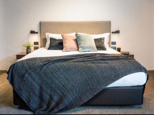 a bedroom with a large bed with pillows at Kamana Lakehouse in Queenstown