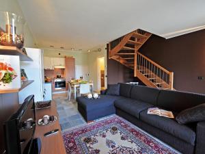 uma sala de estar com um sofá e uma escada em Mansarda Di Pianello em Pianello Del Lario